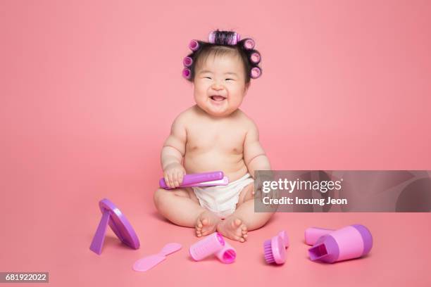 baby girl (6-11 months) with her hair in curlers - hair curlers stock-fotos und bilder