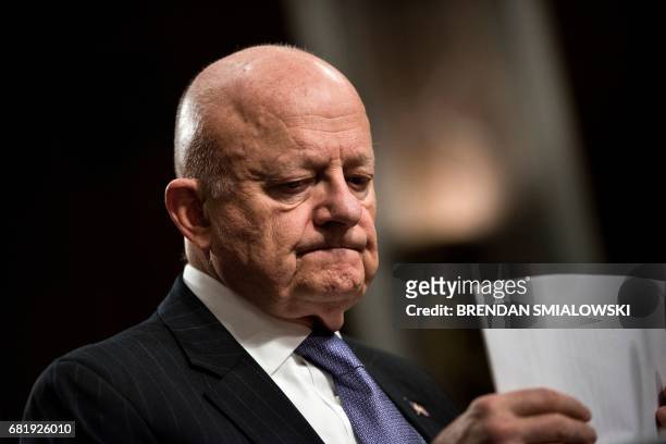 Former Director of National Intelligence James Clapper organizes his papers during a hearing of the Senate Armed Services Committee on Capitol Hill...