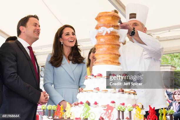 Xavier Bettel, Prime Minister of Luxembourg and Catherine, Duchess of Cambridge view a cake with a cycling design as they tour a cycling themed...