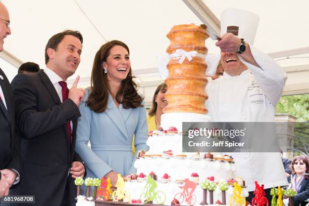 Xavier Bettel, Prime Minister of Luxembourg and Catherine, Duchess of Cambridge view a cake with a cycling design as they tour a cycling themed...