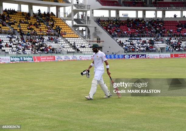 Captain Misbah-ul-Haq of Pakistan leaves the field after getting out for 59 off the bowling of Chase during his final test match, on the second day...