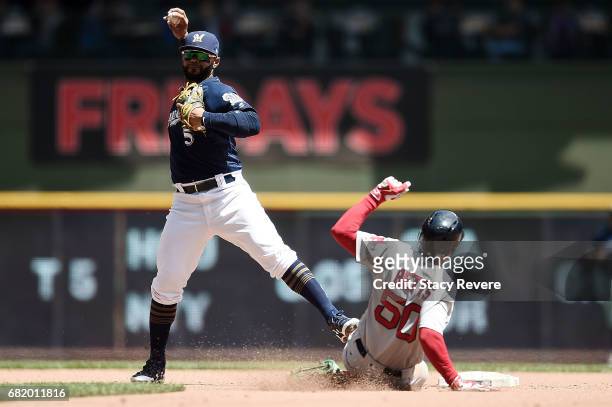 Mookie Betts of the Boston Red Sox is forced out at second base as Jonathan Villar of the Milwaukee Brewers makes a throw to first base during the...