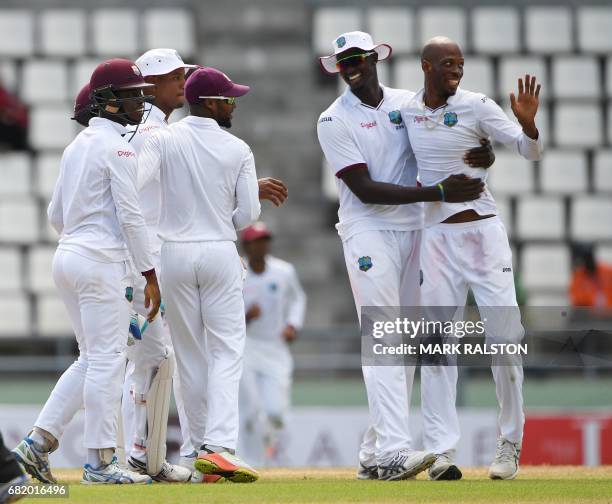 West Indies bowler Roston Chase celebrates with teammates after taking the wicket of Misbah-ul-Haq of Pakistan who is playing his final test match,...