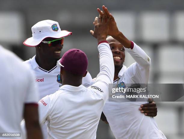 West Indies bowler Roston Chase celebrates with teammates after taking the wicket of Misbah-ul-Haq of Pakistan who is playing his final test match,...