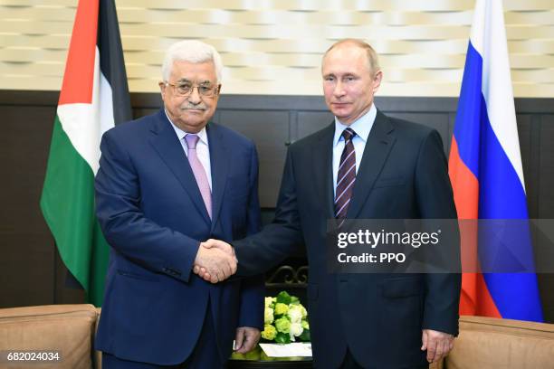 In this handout image provided by the Palestinian Press Office , President Mahmoud Abbas shakes hands with Russian President Vladimir Putin during a...