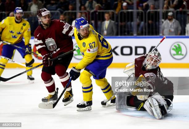 Linus Omark of Sweden fails to score over Elvis Merzlikins, goaltender of Latvia during the 2017 IIHF Ice Hockey World Championship game between...
