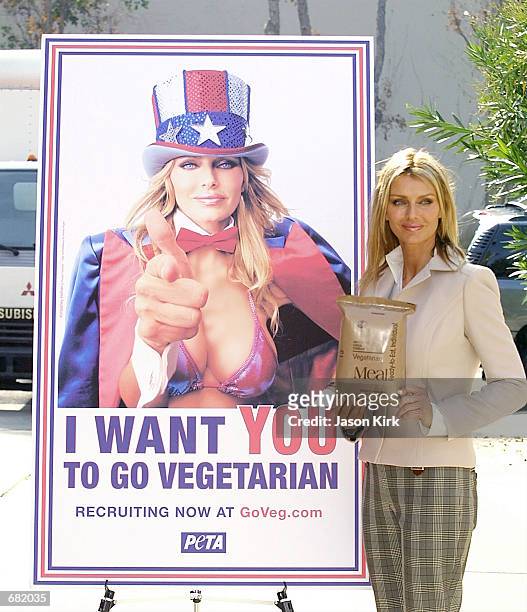 Playboy Playmate Kimberly Hefner poses with a poster for the Ethical Treatment of Animals new ad campaign November 16, 2001 in Culver City, CA. The...