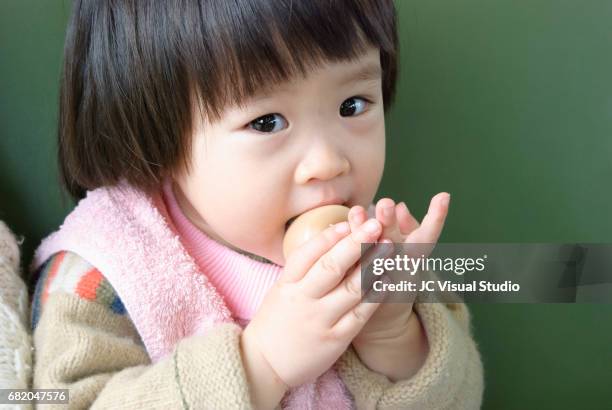 little girl eating an egg - kid boiled egg stock pictures, royalty-free photos & images