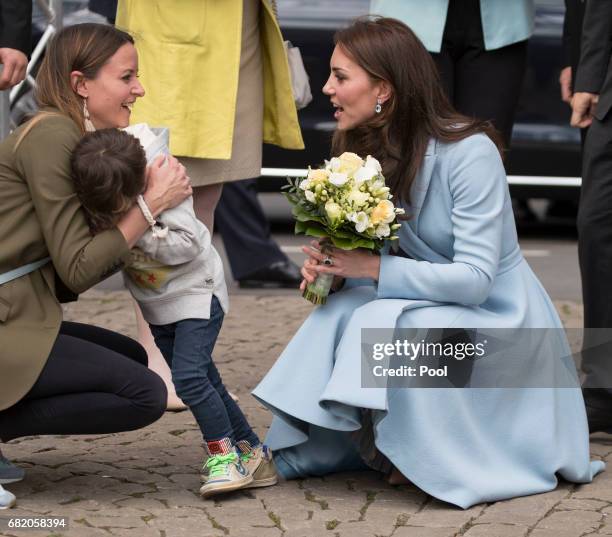 Catherine, Duchess of Cambridge receives flowers from a boy at Place Clairefontaine during a one day visit to Luxembourg on May 11, 2017 in...