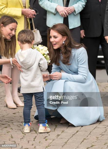 Catherine, Duchess of Cambridge receives flowers from a boy at Place Clairefontaine during a one day visit to Luxembourg on May 11, 2017 in...