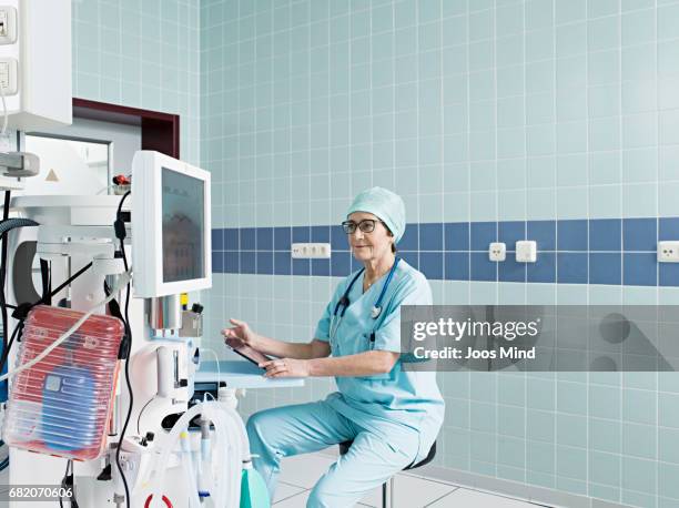 female surgeon using digital tablet, controlling ventilator - person on ventilator stock pictures, royalty-free photos & images