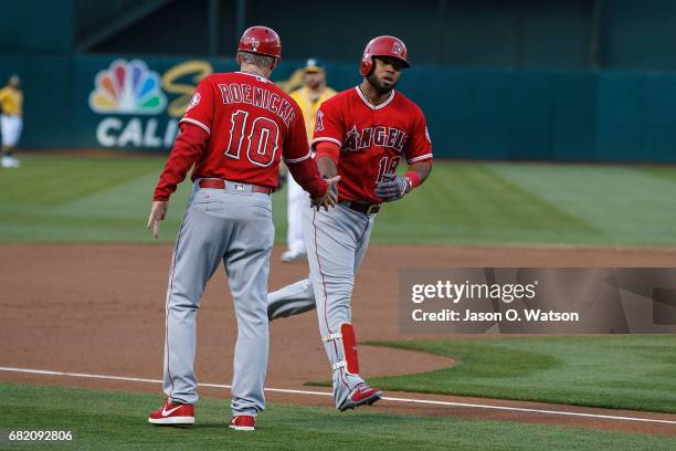 Luis Valbuena of the Los Angeles Angels of Anaheim is congratulated by third base coach Ron Roenicke after hitting a two run home run against the...