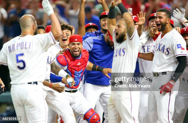 Mike Napoli of the Texas Rangers is congratulated by his teammates for hitting a three run walk off home run in the ninth inning against the San...