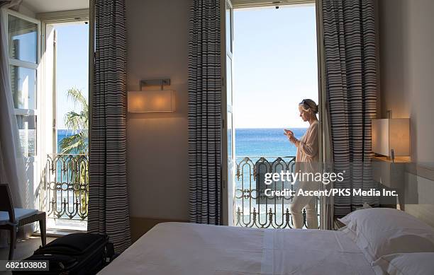 woman relaxes in hotel room, checks text - liguria - fotografias e filmes do acervo