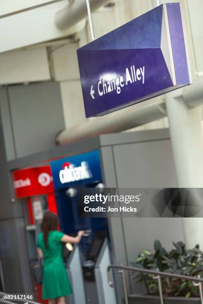 using an atm in change alley, raffles place, singapore. - singapore alley stock pictures, royalty-free photos & images