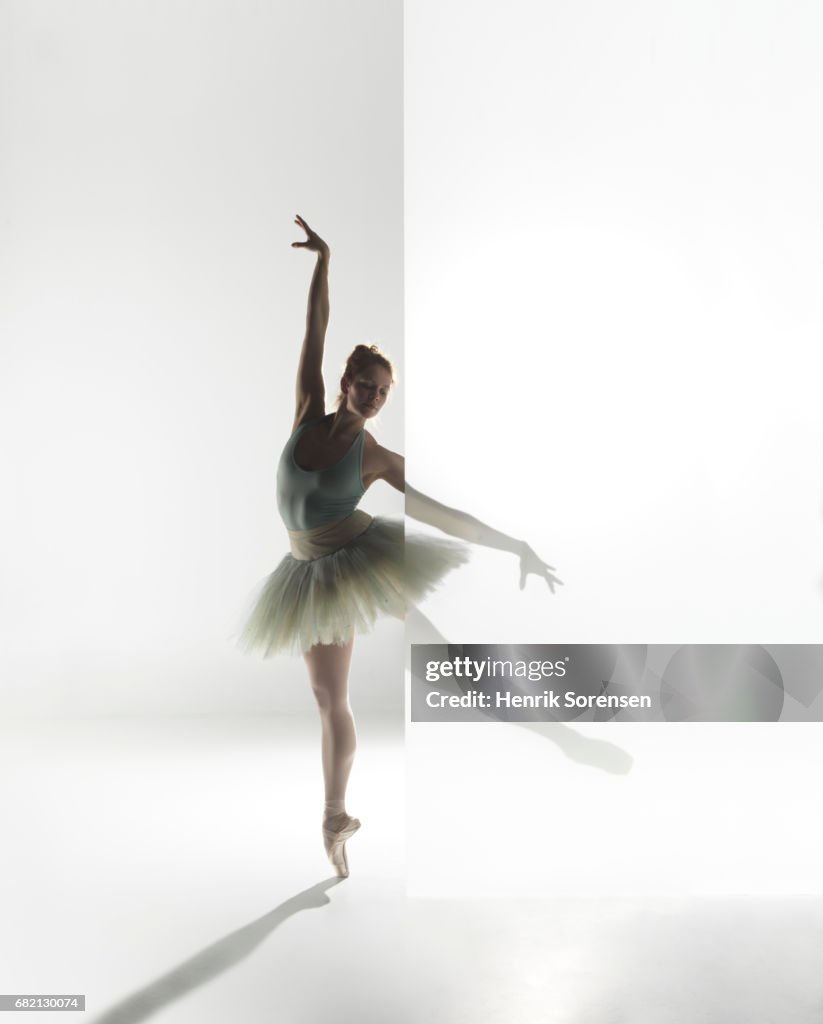 Ballet dancer standing behind a opaque screen