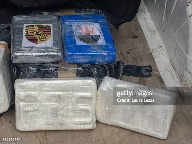 Some bricks of cocaine with Porsche and Maserati cars logos and the initials PRSand VMW are displayed on May 11, 2017 in Livorno, Italy. Black...
