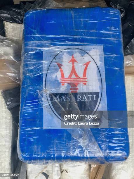Brick of cocaine with the logo Maserati cars is displayed on May 11, 2017 in Livorno, Italy. Black Backpacks roped together and containing 165 Kg of...