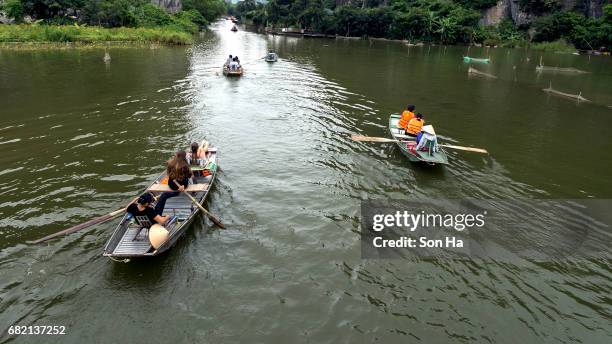 tamcoc , ninhbinh , vietnam - may 5 ,2017 : tourists traveling in boat along the ngo dong river  of the tam coc, ninh binh, vietnam. the landscape formed in karst terrain and rice fields. - dong tam stock pictures, royalty-free photos & images