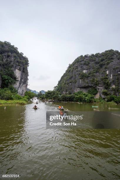 tamcoc , ninhbinh , vietnam - may 5 ,2017 : tourists traveling in boat along the ngo dong river  of the tam coc, ninh binh, vietnam. the landscape formed in karst terrain and rice fields. - dong tam stock pictures, royalty-free photos & images