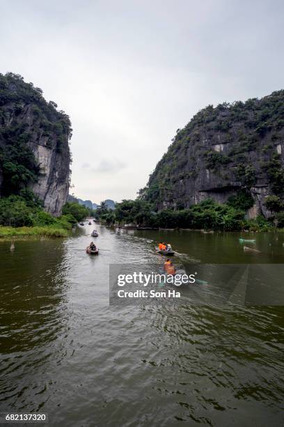 tamcoc , ninhbinh , vietnam - may 5 ,2017 : tourists traveling in boat along the ngo dong river  of the tam coc, ninh binh, vietnam. the landscape formed in karst terrain and rice fields. - dong tam stock pictures, royalty-free photos & images