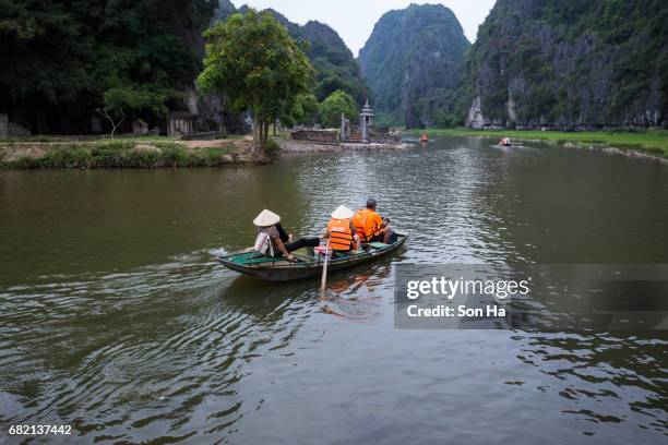 tamcoc , ninhbinh , vietnam - may 5 ,2017 : tourists traveling in boat along the ngo dong river  of the tam coc, ninh binh, vietnam. the landscape formed in karst terrain and rice fields. - dong tam stock pictures, royalty-free photos & images