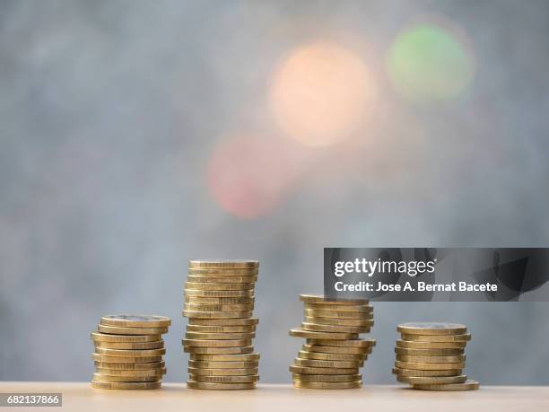 euro and cent coins arranged in heaps of different sizes - zwei euro münze stock-fotos und bilder