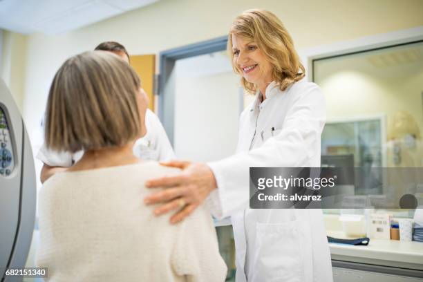 surgeon consoling female patient at hospital - surgeon patient stock pictures, royalty-free photos & images