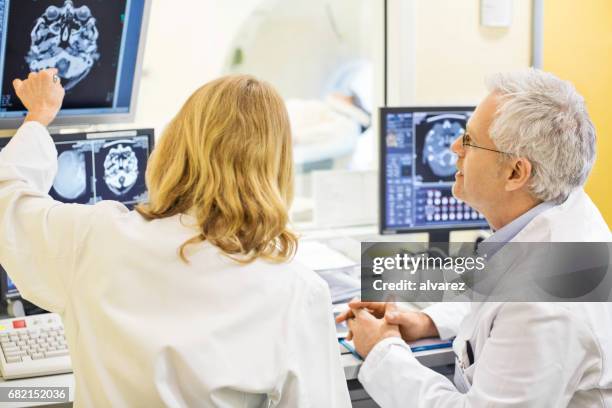 mature doctors analyzing x-ray image at hospital - 70 x 54 stock pictures, royalty-free photos & images