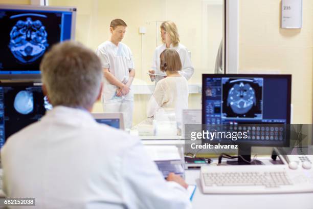 mature doctor analyzing x-rays in examination room - 70 x 54 stock pictures, royalty-free photos & images