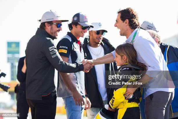 Fernando Alonso of McLaren and Spain meets Pedro De La Rosa's daugher Luna and Pedro De La Rosa both of Spain during previews to the Spanish Formula...