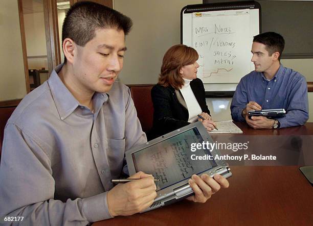 Charlton Lui , a Microsoft development manager, demonstrates an Acer tablet PC prototype November 7, 2001 in Seattle, WA. Microsoft chairman and...