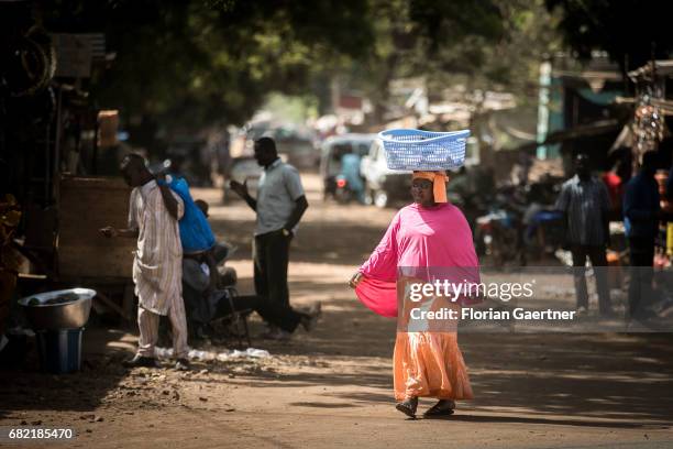 April 07: An African woman carries a laundry basket on her head. Street scene in Bamako on April 07, 2017 in Bamako, Mali.