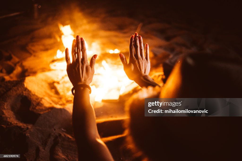 Hands warming up to fireplace