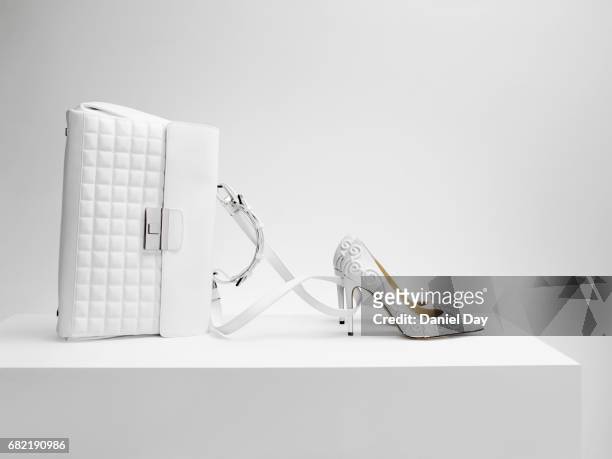 a white bag with white shoes in the form of cinderella's coach - sac à main blanc photos et images de collection