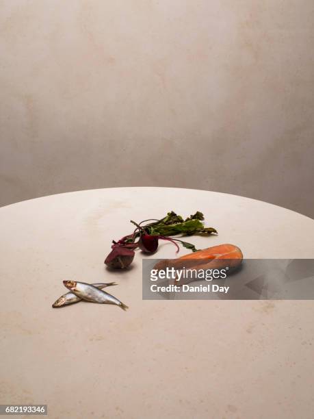 fish and salmon with beetroot lying on a round table with surface texture - round table stock pictures, royalty-free photos & images