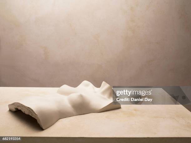 plaster bust of female torso lying on a table, warm lighting - tronco imagens e fotografias de stock