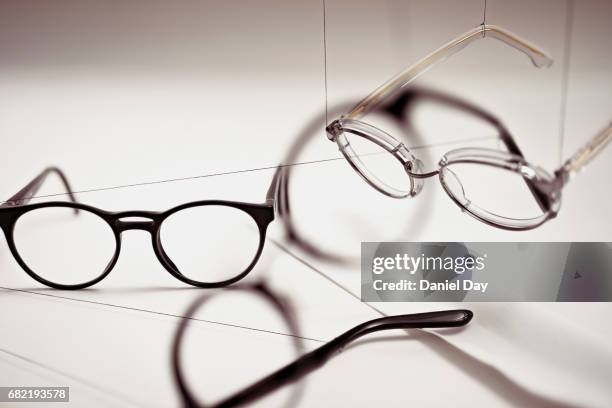 groups of reading glasses hanging and suspended - eyewear stock-fotos und bilder