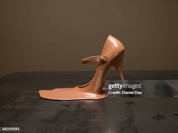 melted shoe on a metal table - metallic shoe stock-fotos und bilder