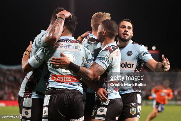The Sharks celebrate with Sosaia Feki of the Sharks after he scored a try during the round 10 NRL match between the St George Illawarra Dragons and...