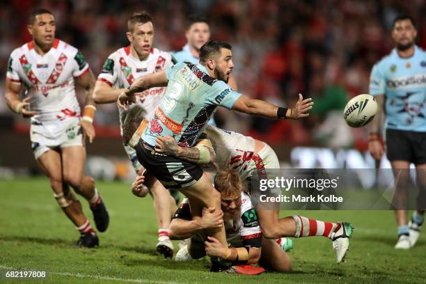 Jack Bird of the Sharks passes as he is tackled during the round 10 NRL match between the St George Illawarra Dragons and the Cronulla Sharks at UOW...