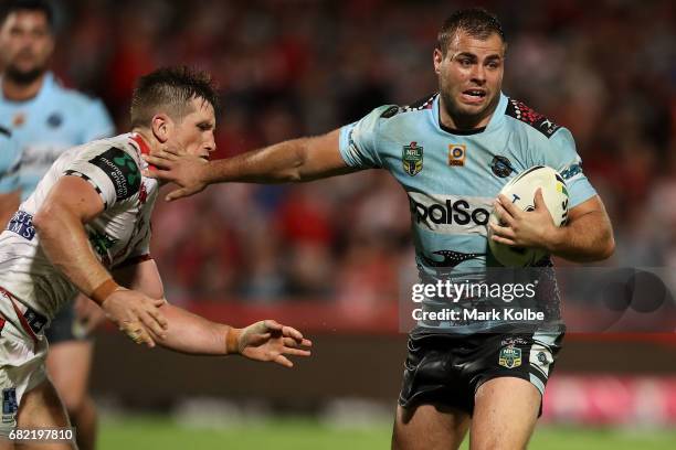 Josh McCrone of the Dragons is fended away by Wade Graham of the Sharks during the round 10 NRL match between the St George Illawarra Dragons and the...