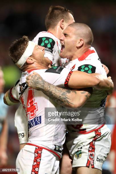 Tariq Sims and Cameron McInnes of the Dragons celebrate with Russell Packer of the Dragons as he celebrates scoring a try during the round 10 NRL...