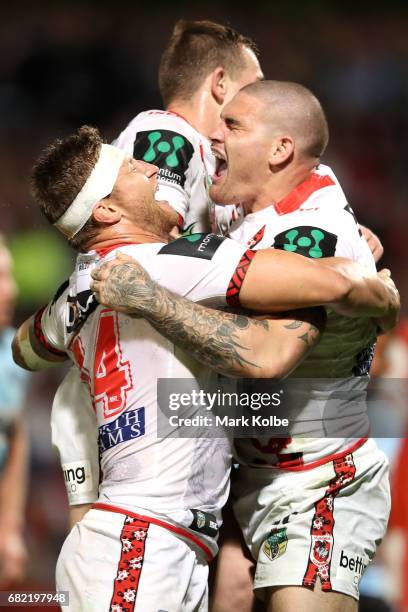 Tariq Sims and Cameron McInnes of the Dragons celebrate with Russell Packer of the Dragons as he celebrates scoring a try during the round 10 NRL...