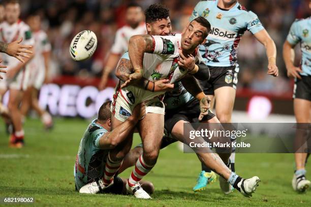 Paul Vaughan of the Dragons passes as he is tackled to Russell Packer of the Dragons to score a try during the round 10 NRL match between the St...