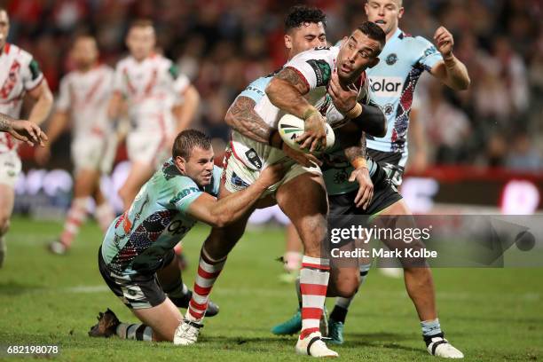 Paul Vaughan of the Dragons passes as he is tackled to Russell Packer of the Dragons to score a try during the round 10 NRL match between the St...