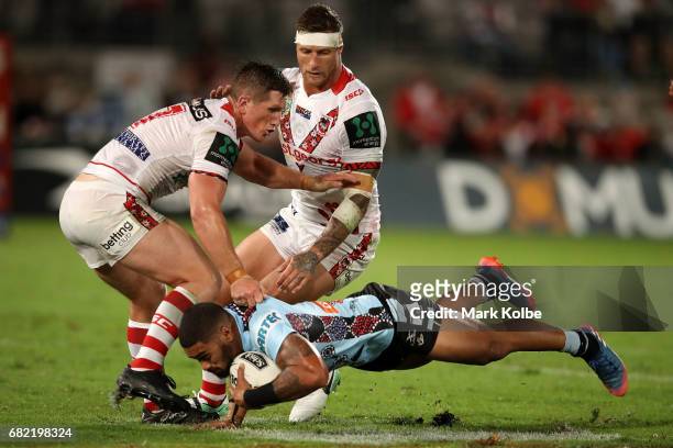 Josh McCrone and Tariq Sims of the Dragons tackle Ricky Leutele of the Sharks during the round 10 NRL match between the St George Illawarra Dragons...