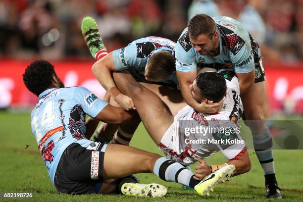 Joseph Paulo, Jayden Brailey and Wade Graham of the Sharks tackle Tim Lafai of the Dragons during the round 10 NRL match between the St George...