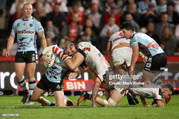 Jack Bird of the Sharks tries to get to his feet under pressure from Joel Thompson of the Dragons during the round 10 NRL match between the St George...