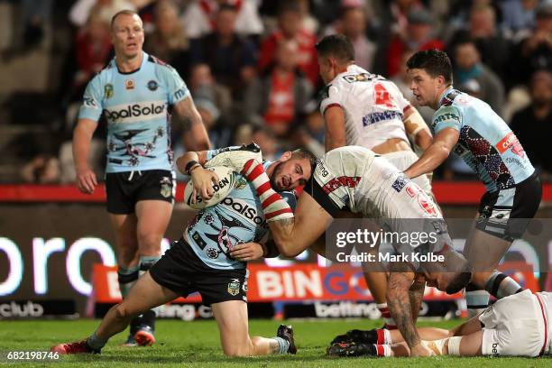 Jack Bird of the Sharks tries to get to his feet under pressure from Joel Thompson of the Dragons during the round 10 NRL match between the St George...